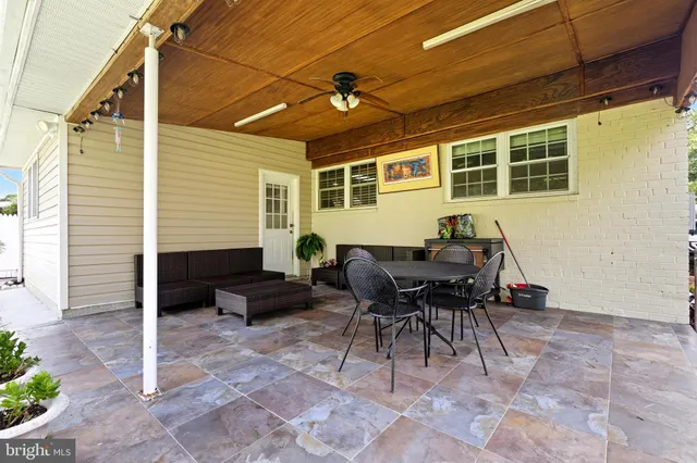 a backyard of a house with fire pit table and chairs