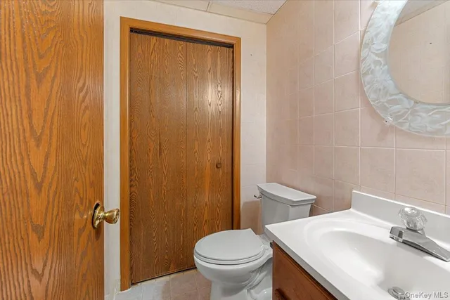 a bathroom with a granite countertop sink toilet and a mirror