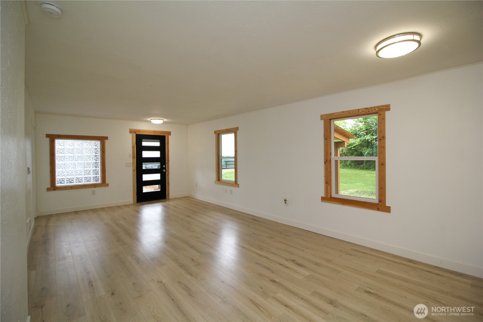 10341 184th Avenue Southwest Rochester, WA 98579 - Photo 5 of 36 an empty room with wooden floor and windows