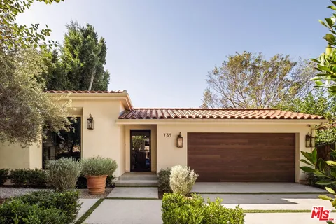 a front view of a house with plants
