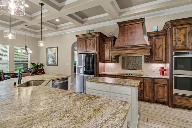 a kitchen with stainless steel appliances granite countertop a sink a stove and cabinets
