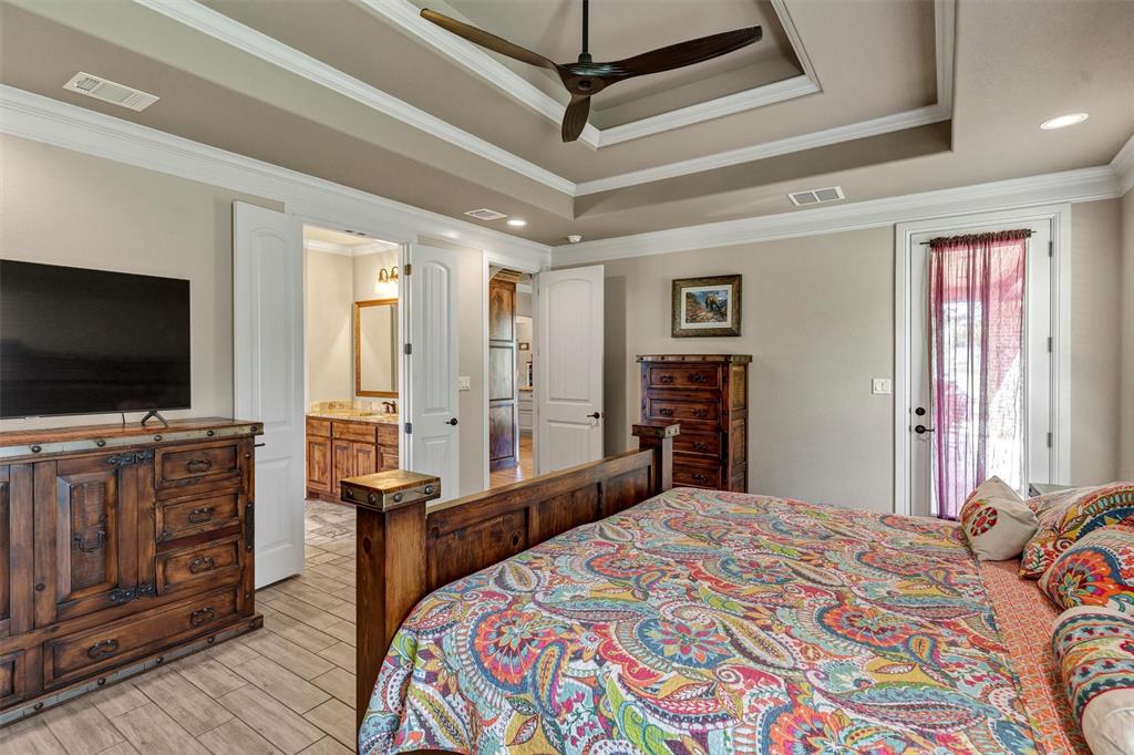 4030 Neri Oaks Court Granbury, TX 76048 - Photo 20 of 40 a bedroom with a bed and a flat screen tv