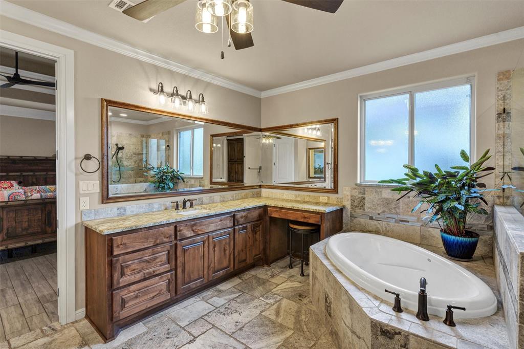 4030 Neri Oaks Court Granbury, TX 76048 - Photo 23 of 40 a bathroom with a granite countertop sink a large mirror and a bathtub