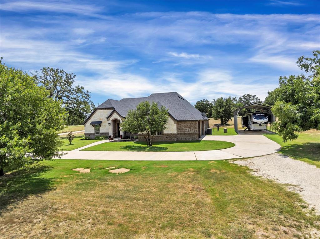 4030 Neri Oaks Court Granbury, TX 76048 - Photo 3 of 40 a view of a house with a big yard and palm trees