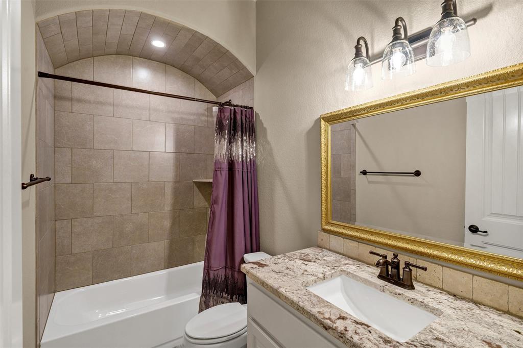 4030 Neri Oaks Court Granbury, TX 76048 - Photo 31 of 40 a bathroom with a granite countertop sink a mirror and a bathtub