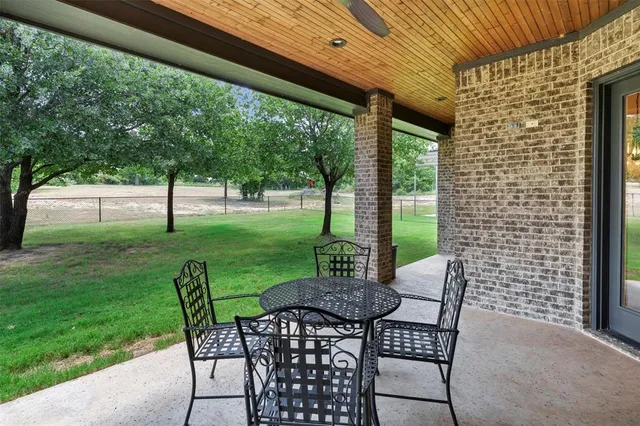 a view of a patio with a table chairs and a backyard