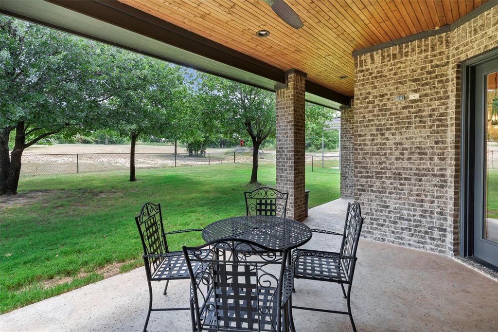 4030 Neri Oaks Court Granbury, TX 76048 - Photo 33 of 40 a view of a patio with a table chairs and a backyard
