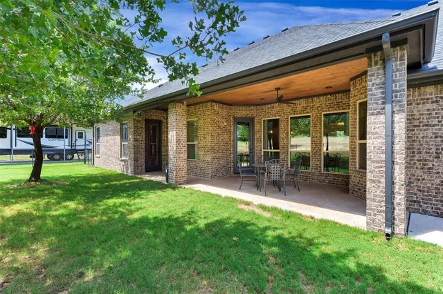 a view of a chair and table in backyard of the house