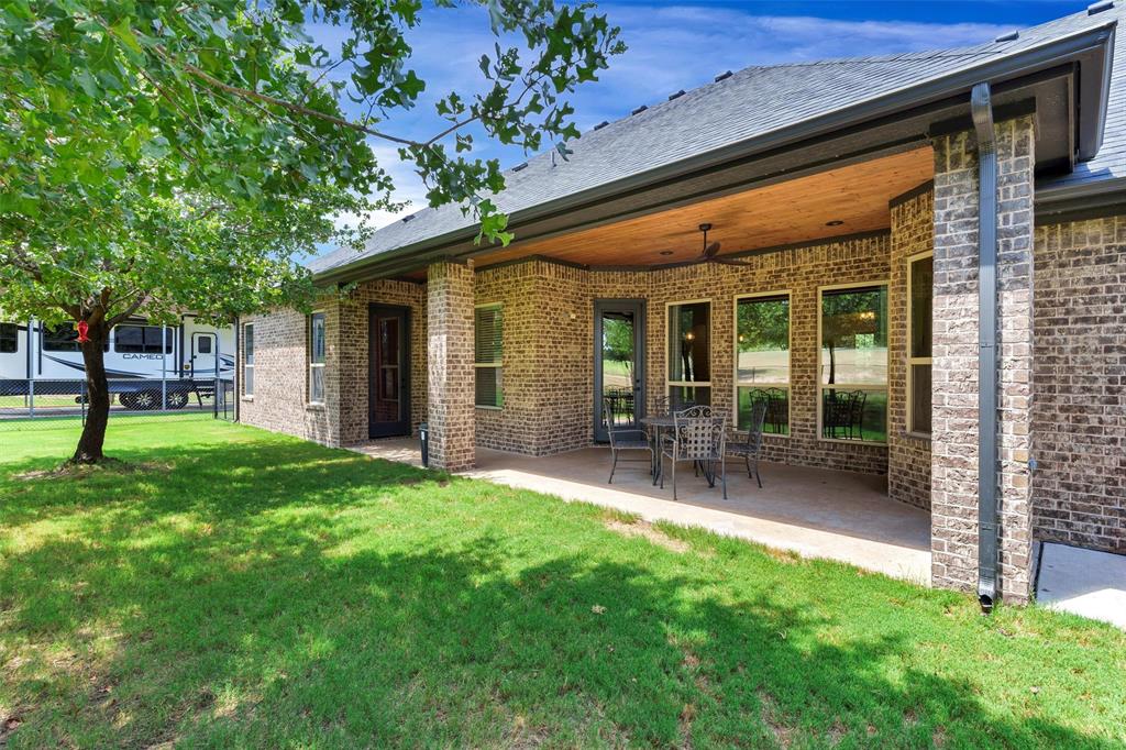 4030 Neri Oaks Court Granbury, TX 76048 - Photo 34 of 40 a view of a chair and table in backyard of the house
