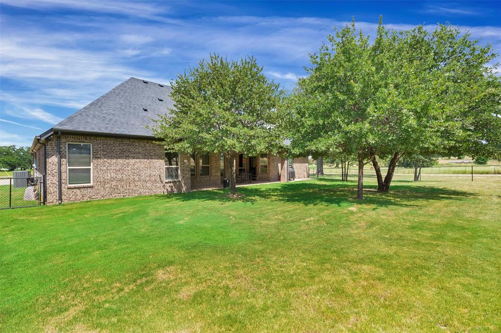4030 Neri Oaks Court Granbury, TX 76048 - Photo 35 of 40 a front view of a house with a garden