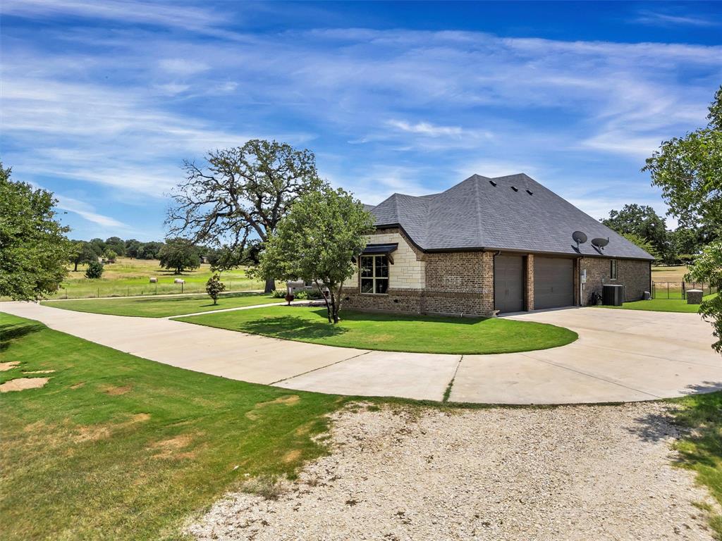 4030 Neri Oaks Court Granbury, TX 76048 - Photo 4 of 40 a front view of a house with a yard and garage