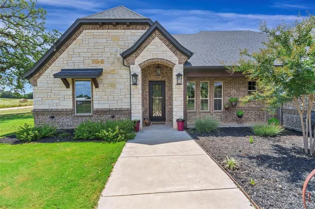 a front view of a house with a garden
