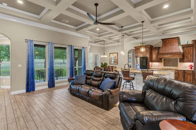 a living room with furniture ceiling fan and a large window