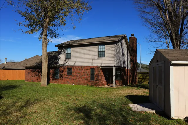 a view of a house with a yard and tree