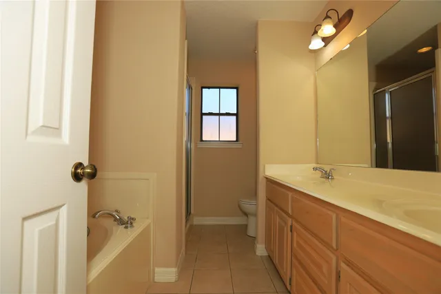 a bathroom with a granite countertop sink a toilet and shower