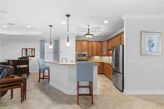 a open kitchen with stainless steel appliances kitchen island granite countertop a refrigerator a stove and a sink with granite countertops
