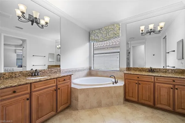 a bathroom with a granite countertop bathtub a sink and a mirror