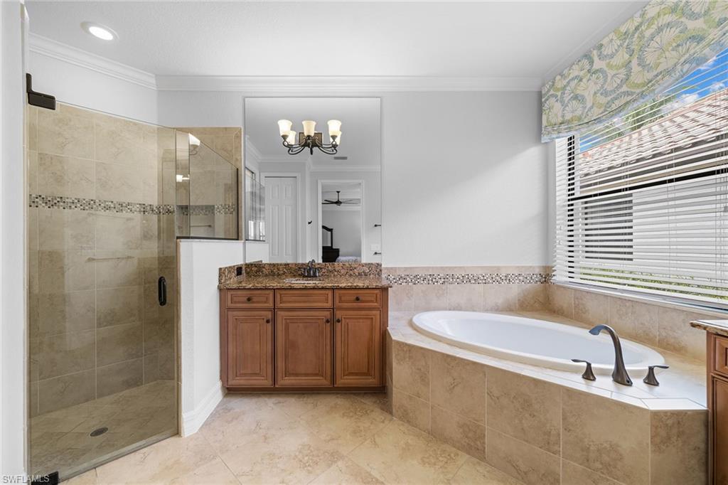 12614 Fenhurst Way Naples, FL 34120 - Photo 23 of 50 a bathroom with a granite countertop bathtub shower sink and mirror