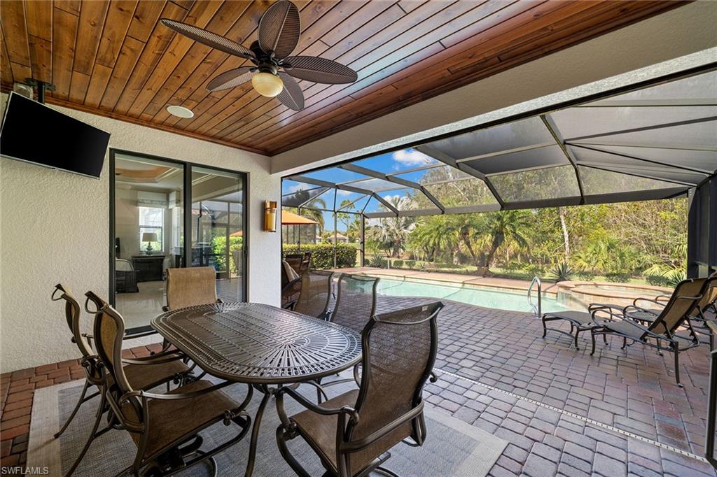 12614 Fenhurst Way Naples, FL 34120 - Photo 33 of 50 a view of a patio with table and chairs under an umbrella