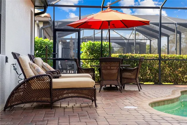 a patio with a table and chairs under an umbrella