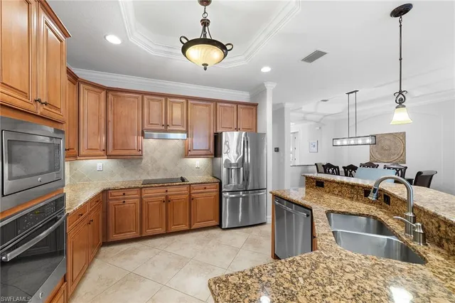 a kitchen with stainless steel appliances granite countertop a sink stove and refrigerator