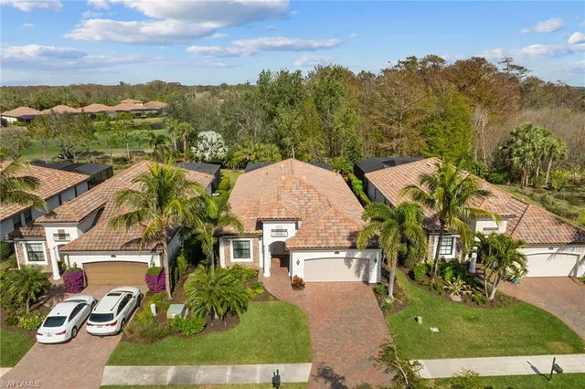 an aerial view of residential houses with outdoor space and trees