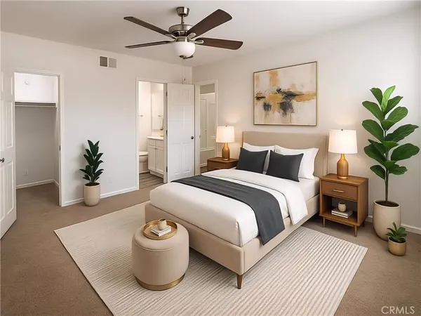 a bedroom with a large bed and a potted plant