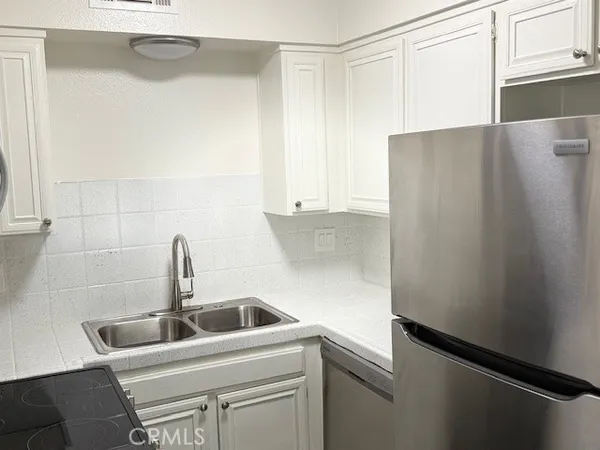 a close view of a sink and refrigerator in kitchen