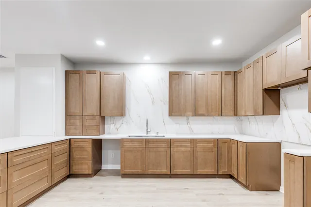 a large kitchen with a sink a window and stainless steel appliances