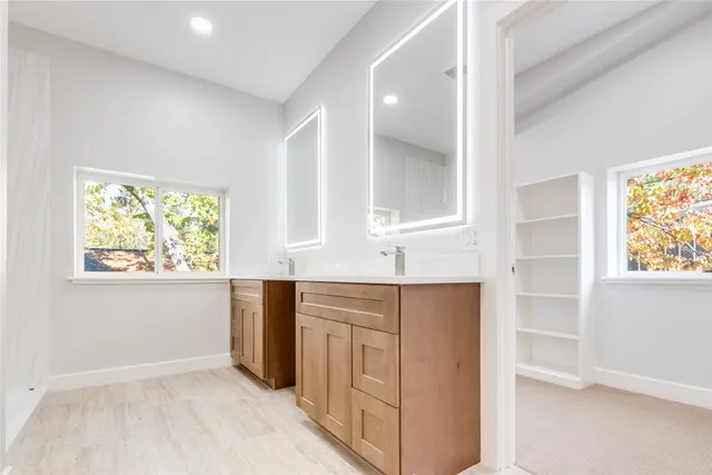 a kitchen with white cabinets and window