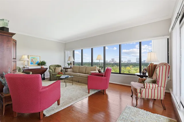 a living room with furniture floor to ceiling window and wooden floor