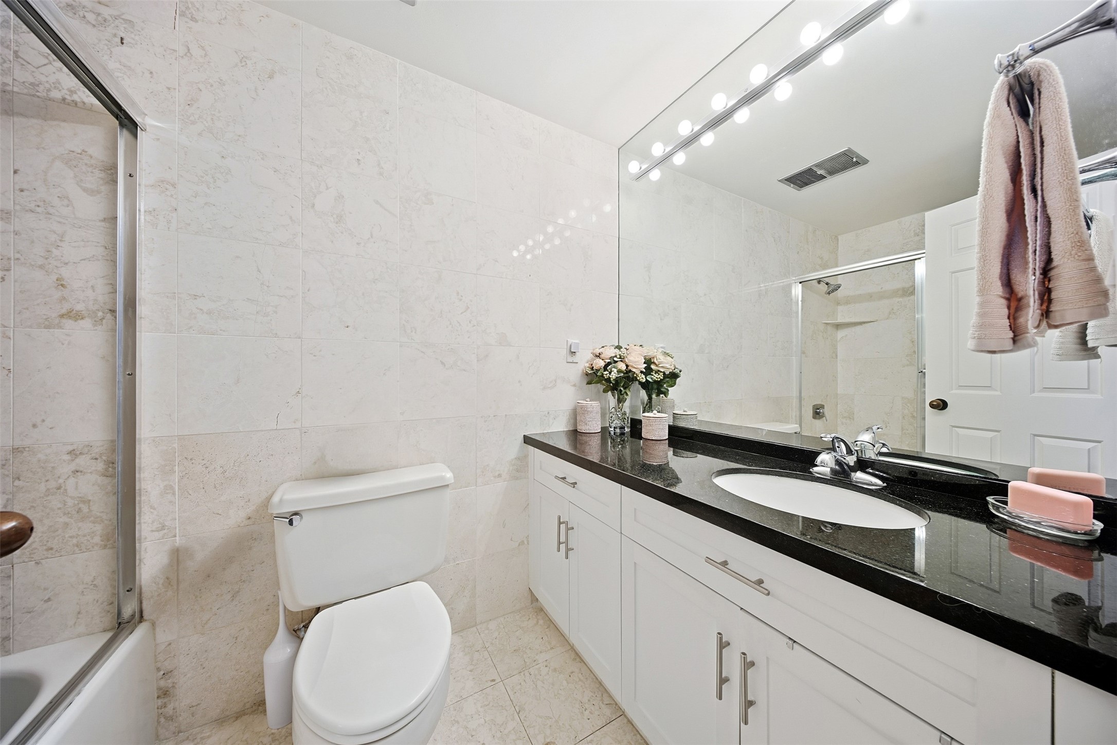 2001 Holcombe Boulevard, Unit 1106 Houston, TX 77030 - Photo 20 of 50 The secondary bathroom features a neutral color scheme, highlighted by white cabinetry and complemented by black countertops.