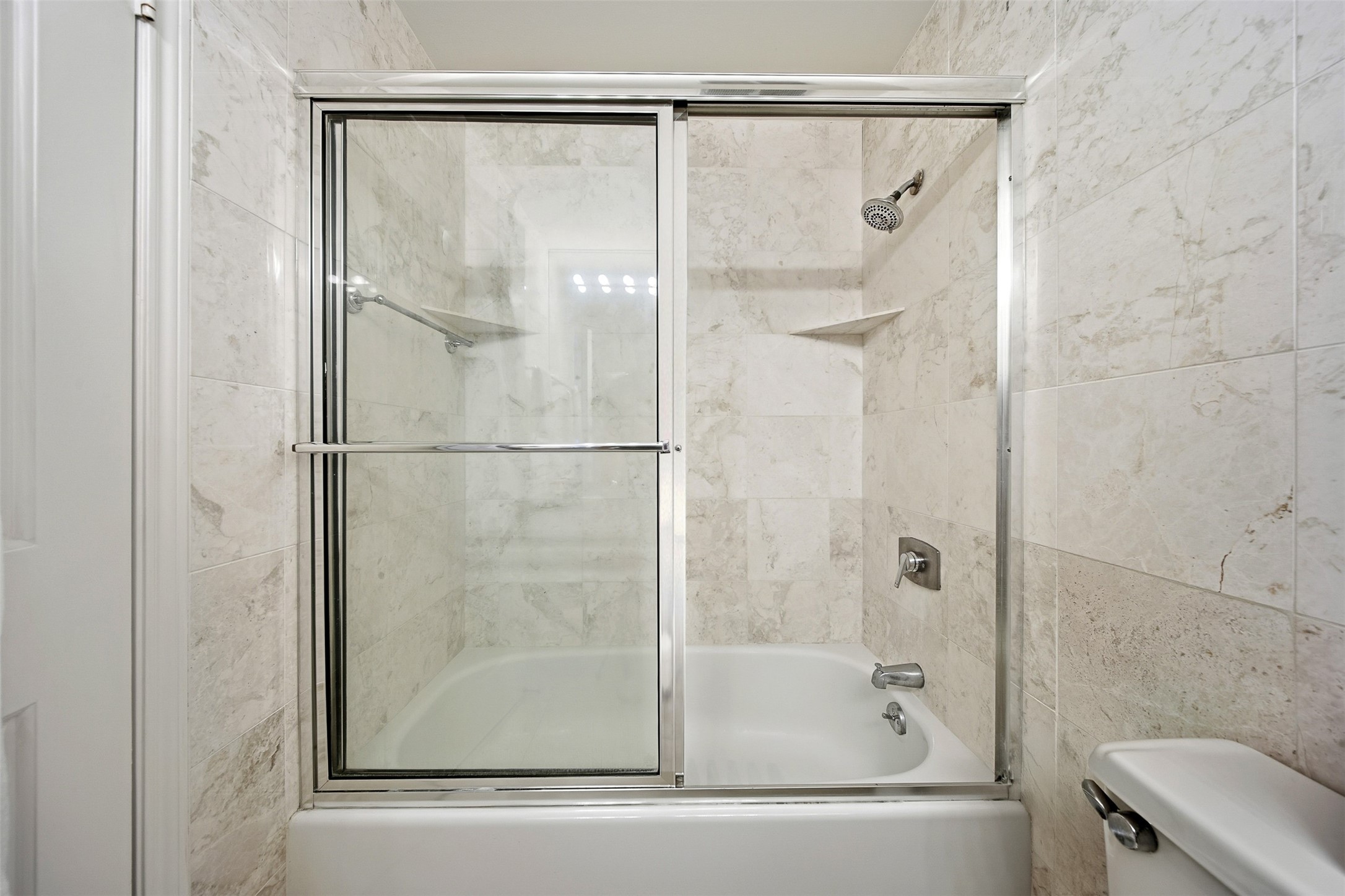 2001 Holcombe Boulevard, Unit 1106 Houston, TX 77030 - Photo 21 of 50 The second bathroom features a combined shower and tub, complete with a sliding glass enclosure.