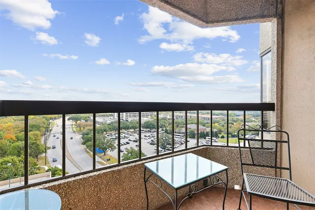 a view of a city from a balcony with furniture
