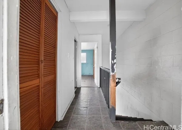 a view of a hallway with wooden floor and staircase