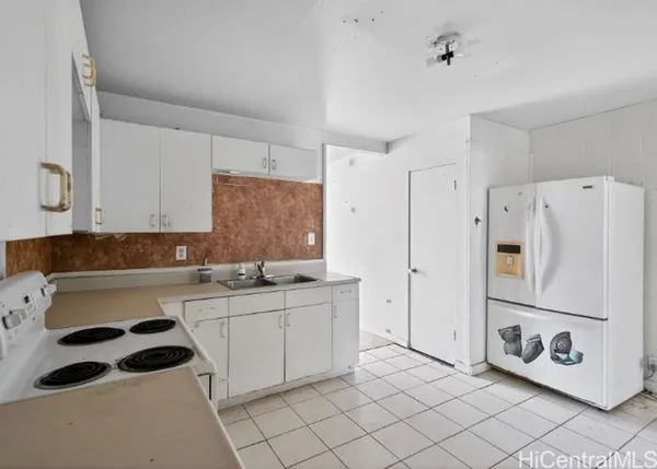 a kitchen with a sink a refrigerator and cabinets