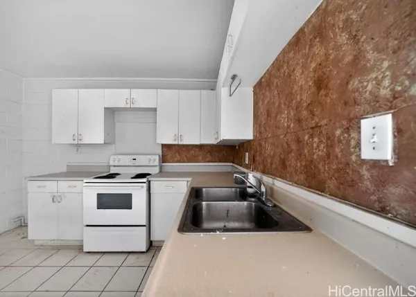 a kitchen with a stove sink and cabinets