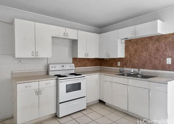 a kitchen with white cabinets appliances and sink