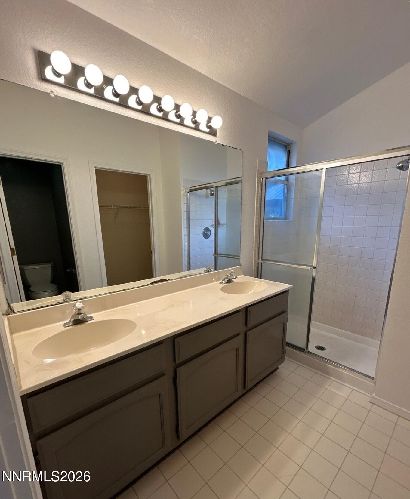 4771 Amber Hill Lane Reno, NV 89523 - Photo 13 of 20 a spacious bathroom with a double vanity sink a large mirror and shower