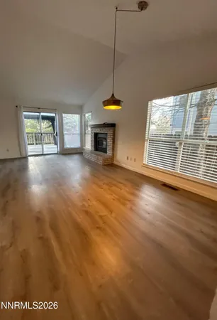 a view of an empty room with a window and fireplace