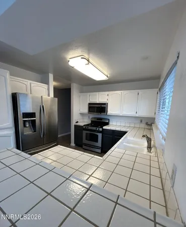 a kitchen with stainless steel appliances kitchen island granite countertop a refrigerator and a stove top oven