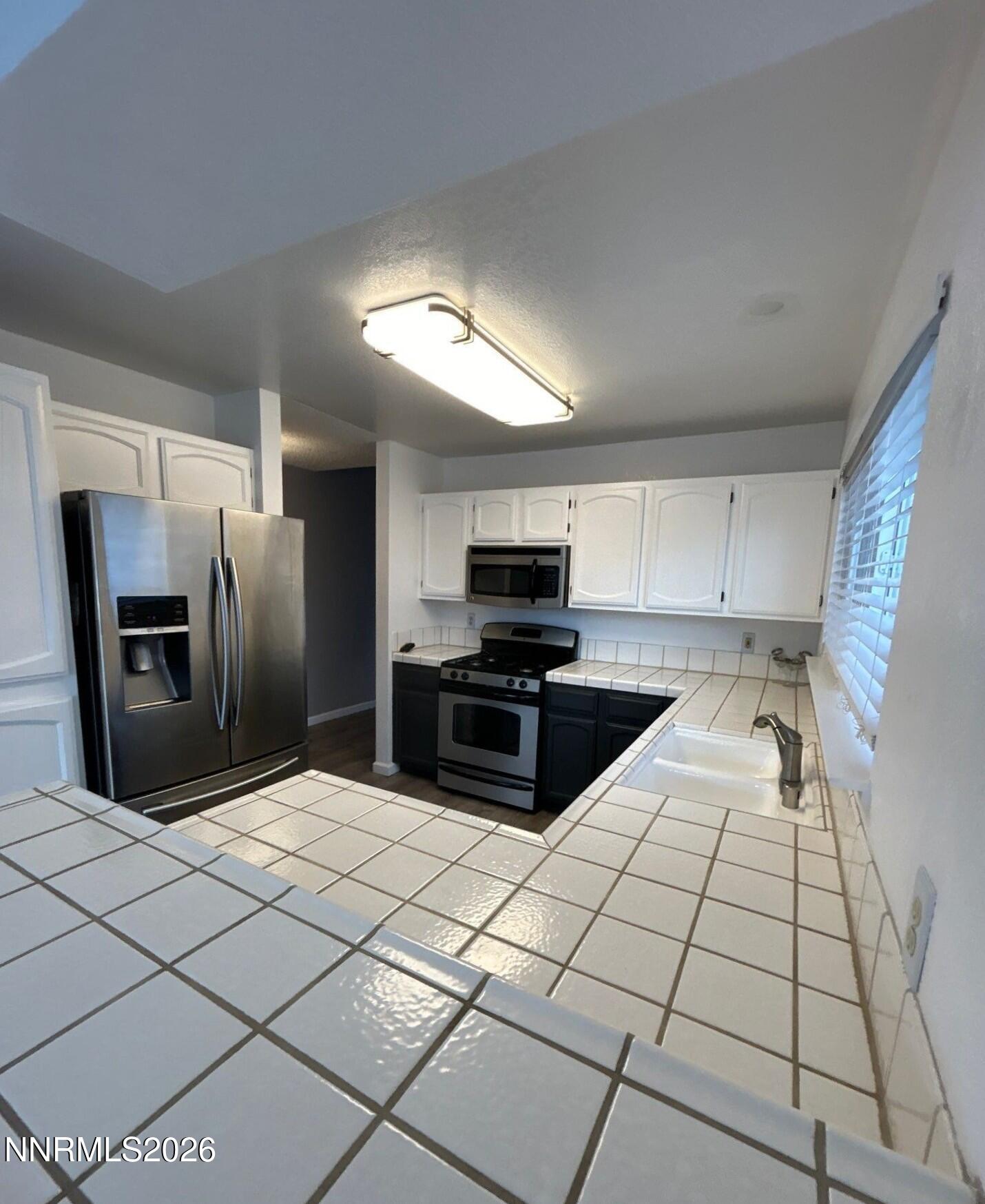 4771 Amber Hill Lane Reno, NV 89523 - Photo 5 of 20 a kitchen with stainless steel appliances kitchen island granite countertop a refrigerator and a stove top oven