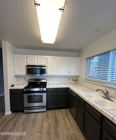 a kitchen with stainless steel appliances kitchen island granite countertop a sink and a stove top oven