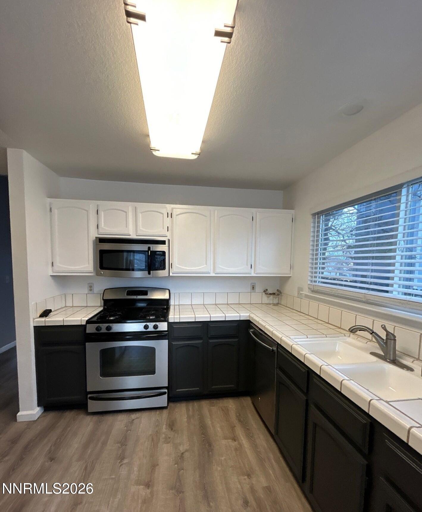 4771 Amber Hill Lane Reno, NV 89523 - Photo 6 of 20 a kitchen with stainless steel appliances kitchen island granite countertop a sink and a stove top oven