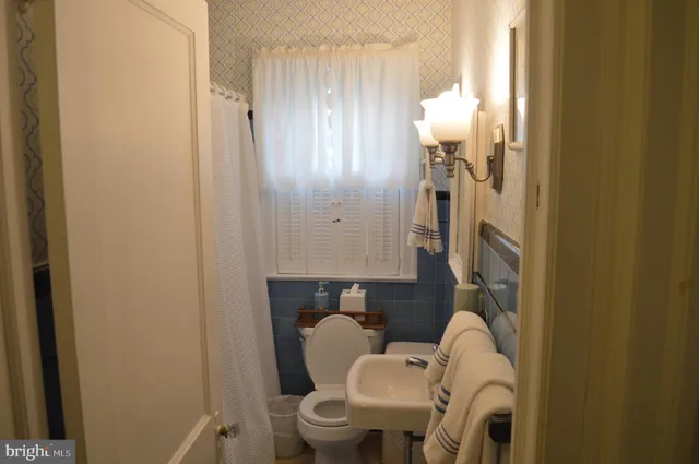 a bathroom with a toilet sink and mirror