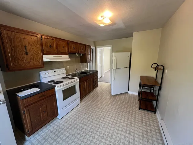a kitchen with a stove a refrigerator and a microwave