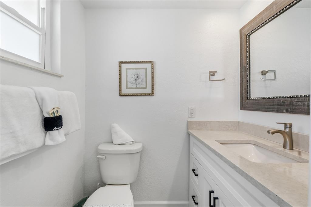 6154 Midnight Pass Road, Unit A05 Sarasota, FL 34242 - Photo 16 of 39 a bathroom with a sink toilet and a mirror