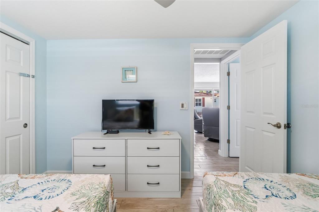 6154 Midnight Pass Road, Unit A05 Sarasota, FL 34242 - Photo 18 of 39 a bedroom with a bed and a flat screen tv
