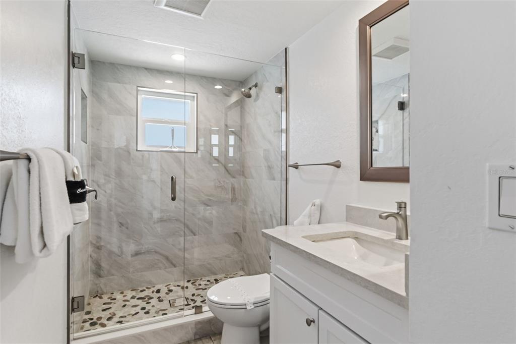 6154 Midnight Pass Road, Unit A05 Sarasota, FL 34242 - Photo 20 of 39 a bathroom with a sink toilet and shower