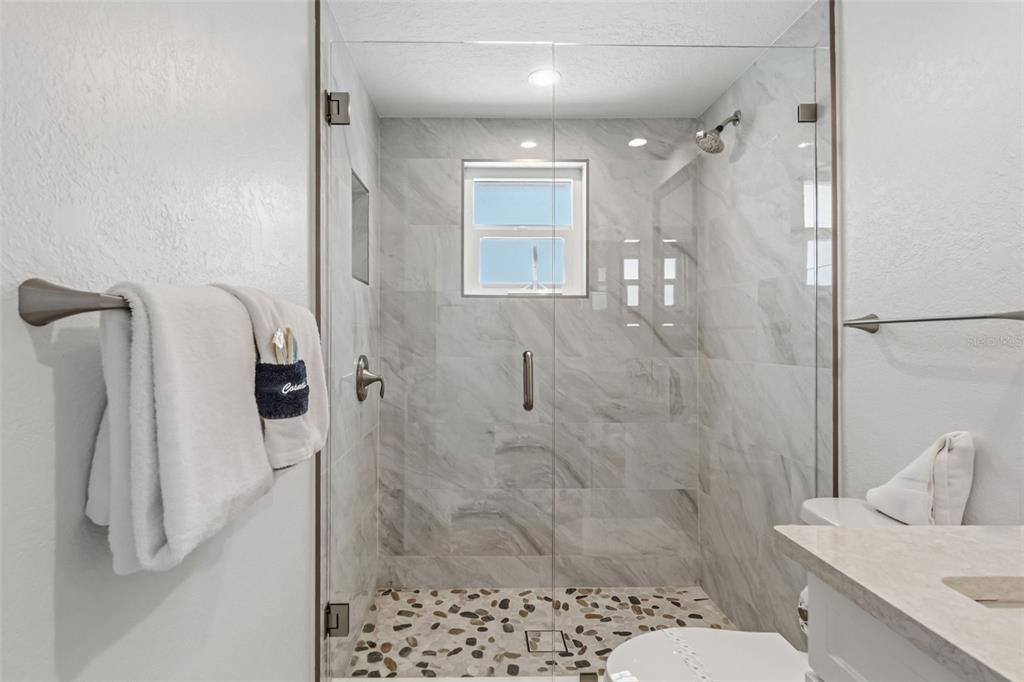 6154 Midnight Pass Road, Unit A05 Sarasota, FL 34242 - Photo 21 of 39 a bathroom with a shower and toilet